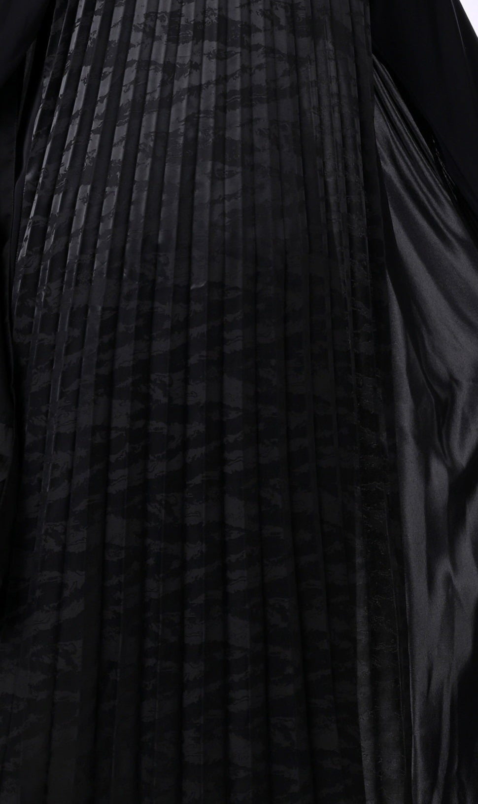 Black abaya worn by a person on a white background