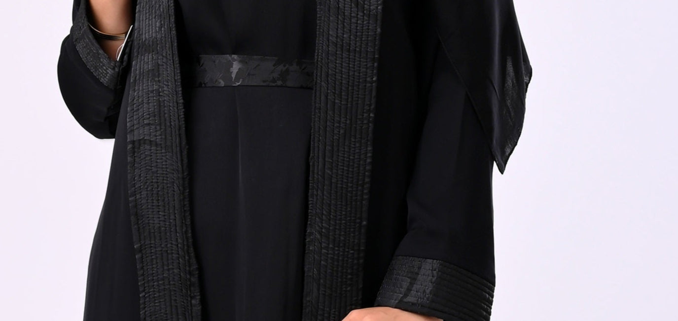 Person wearing a black martial arts uniform with a white background